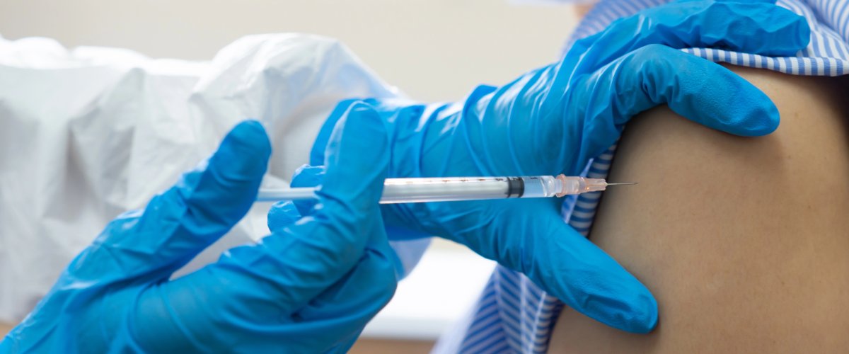 Flu Shots in Cambridge Healthcare worker administering a flu shot injection into a patient’s arm